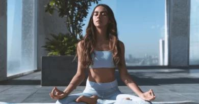 Imagem mostra uma jovem sentada em posição de meditação.