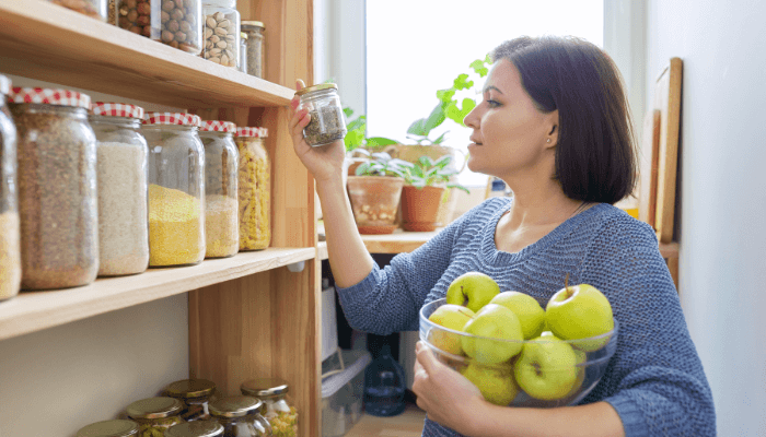 Vários potes transparentes com alimentos, simbolizando um dos cuidados com a casa que é a organização da despensa.